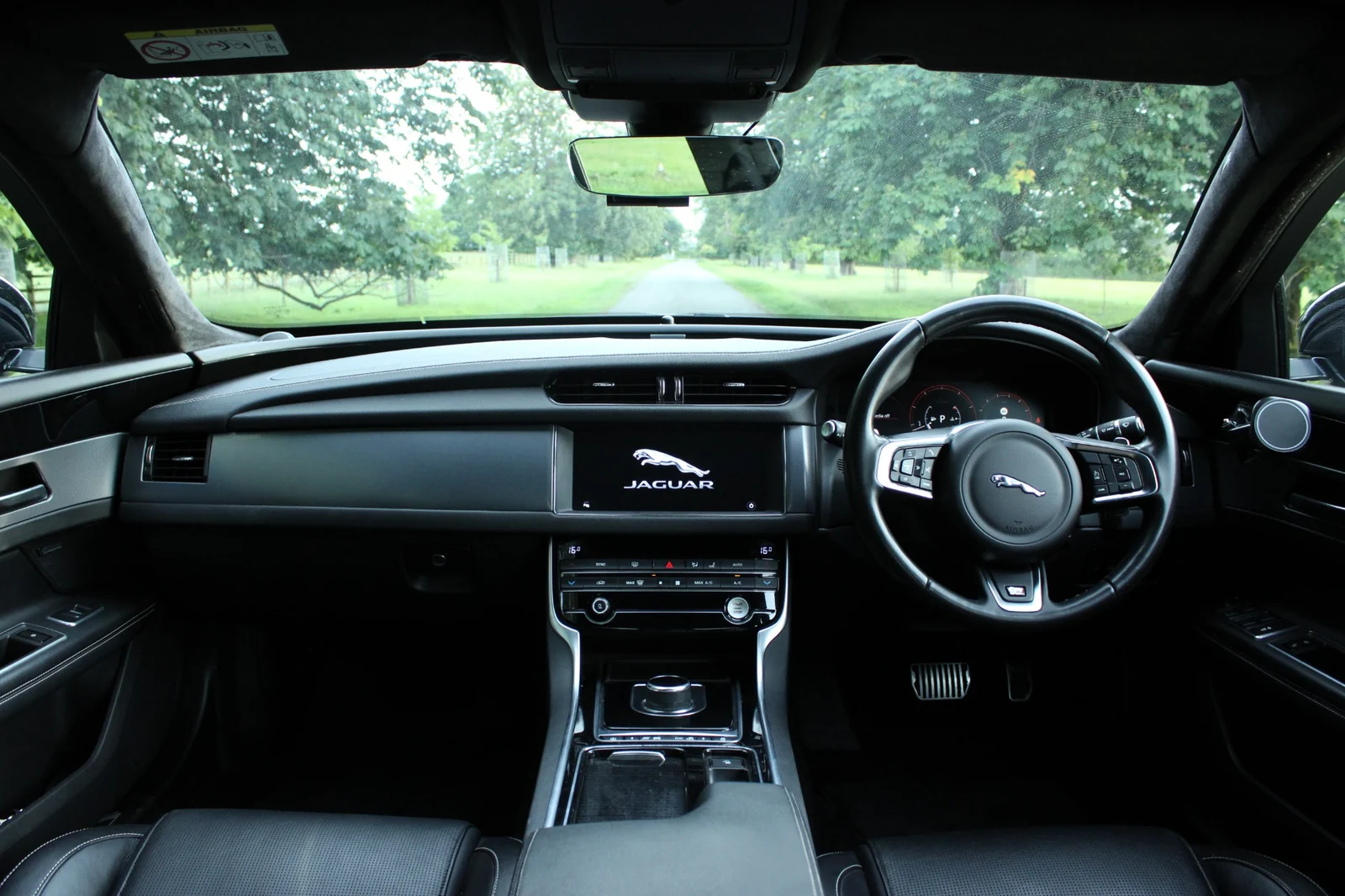 A wide view of a Jaguar dashboard, centre console and steering wheel.