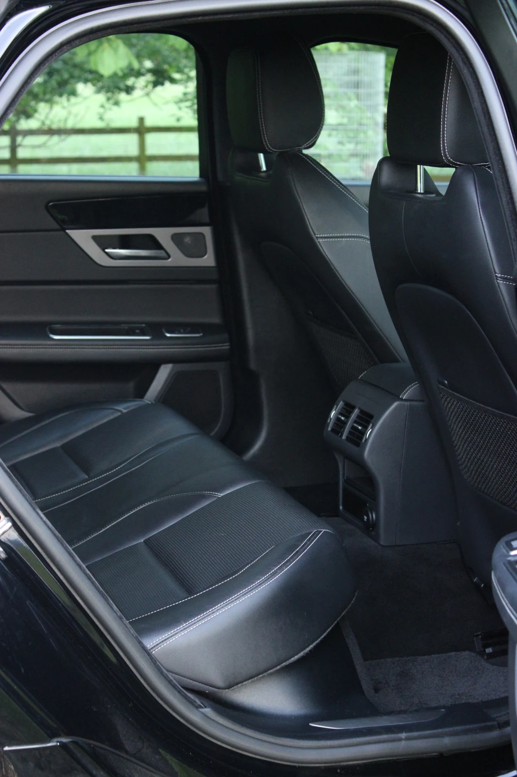 A vertical photograph of the front leather seats in a Jaguar.